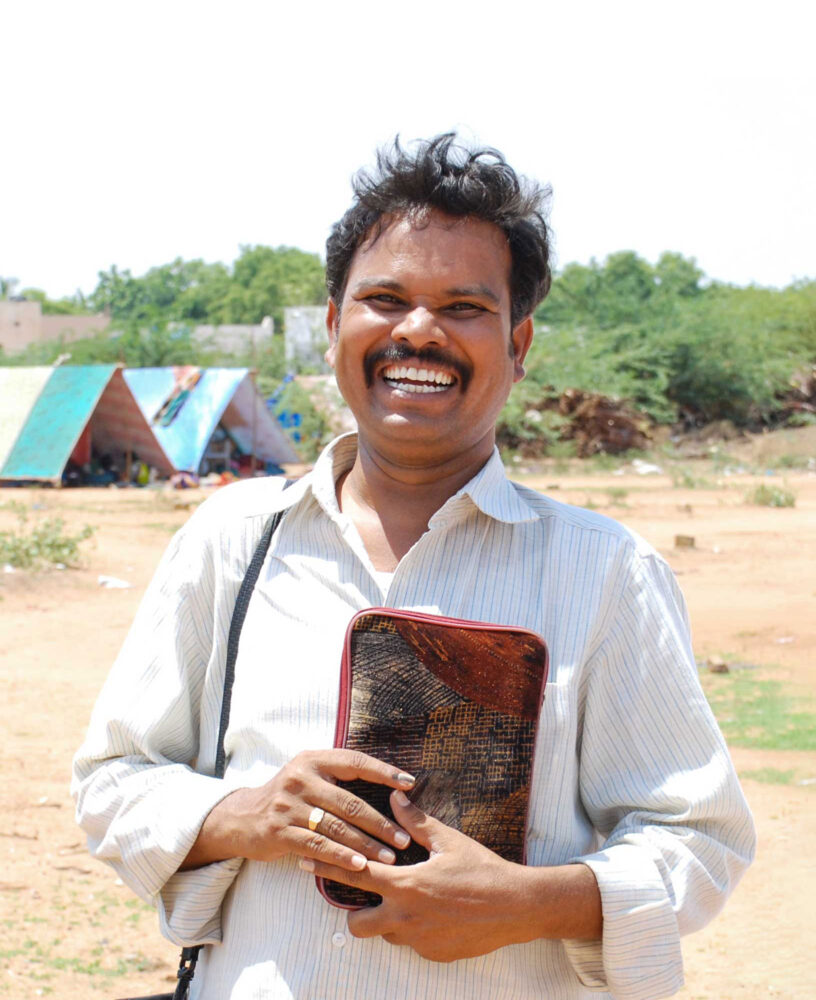 Man holding bible, smiling.