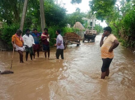 Indian men standing in flooded road