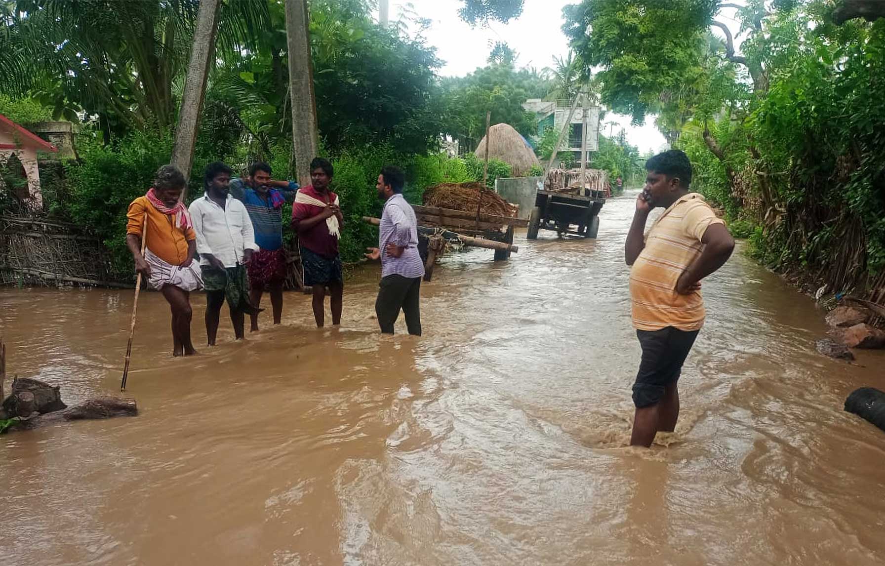 Indian men standing in flooded road